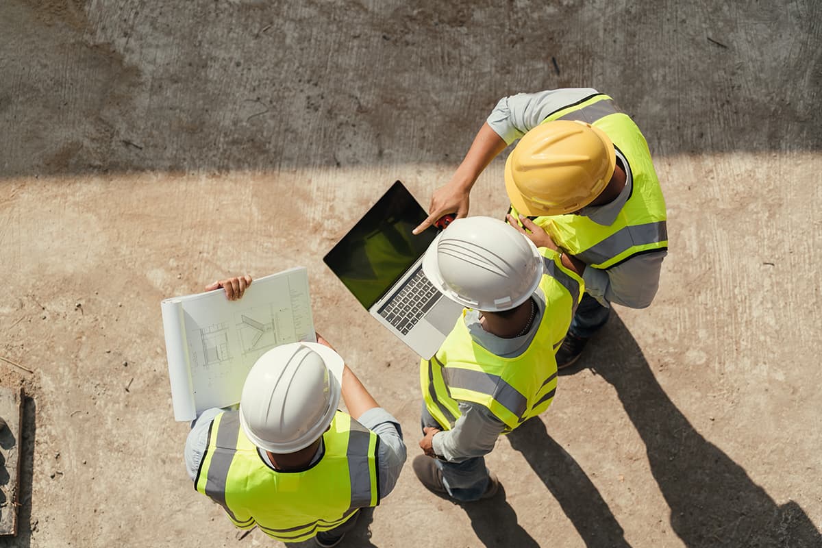 Team engineer building inspection use computer laptop and blueprint working at construction site.